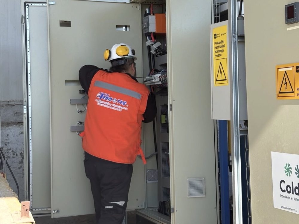 Técnico con casco y protección auditiva interviniendo un tablero eléctrico